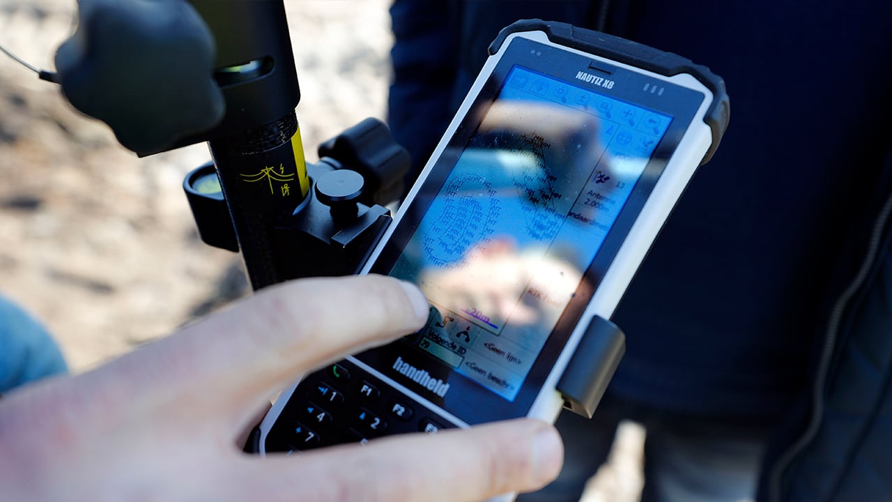 Handheld Nautiz X8 docked on a pole mount in field