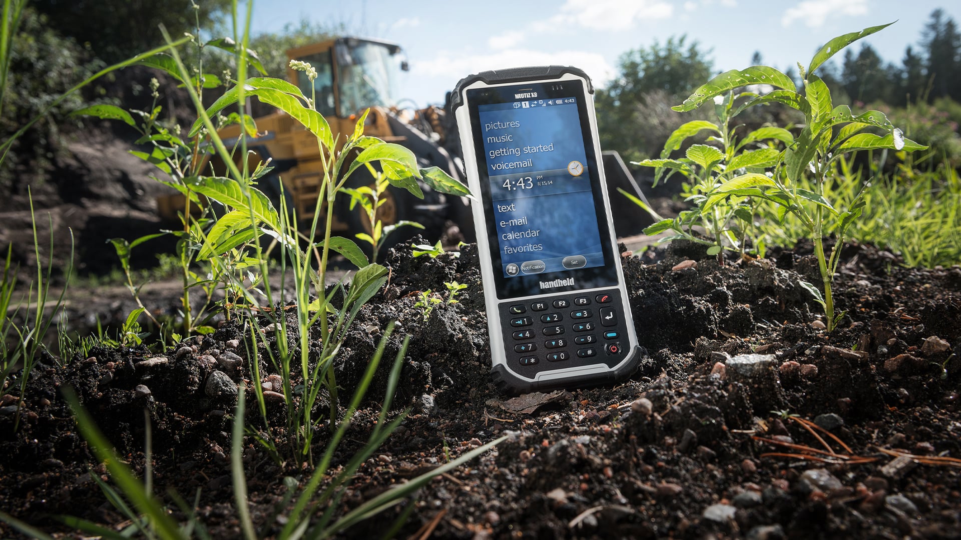 handheld nautiz x8 on ground next to plants